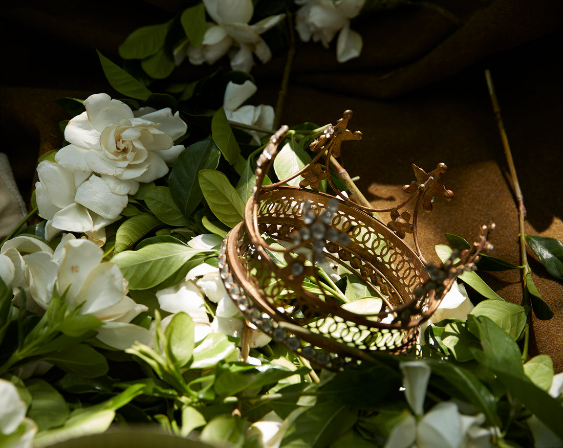 gold crown among bed of gardenia flowers