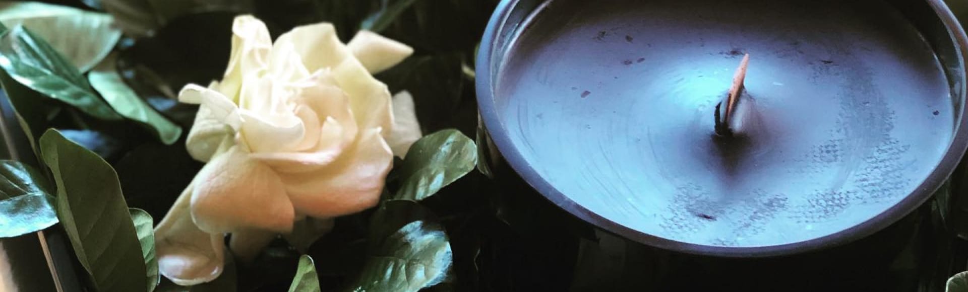 A gardenia next to a beautiful candle